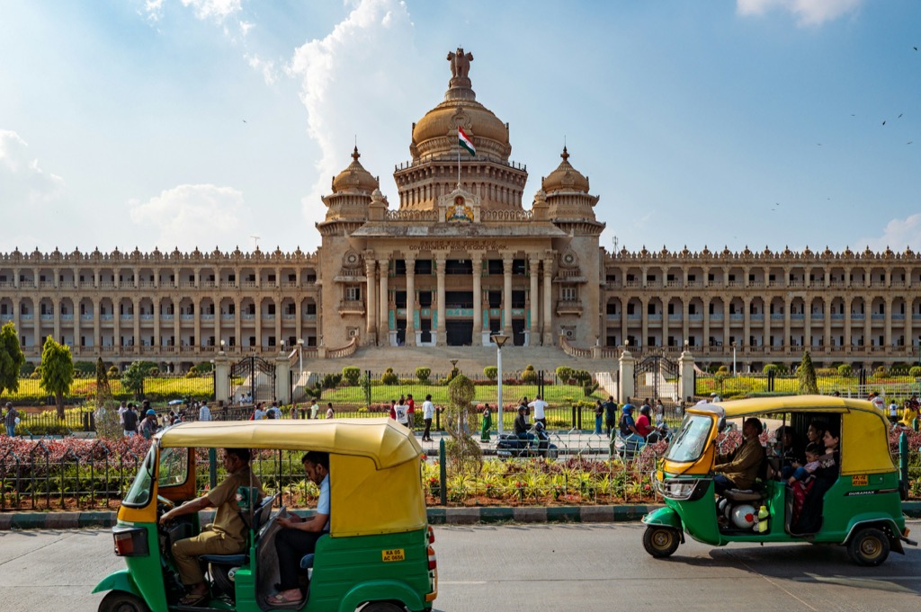 Vidhana Soudha in Bengaluru, with the city's iconic green and yellow auto-rickshaws in the foreground
